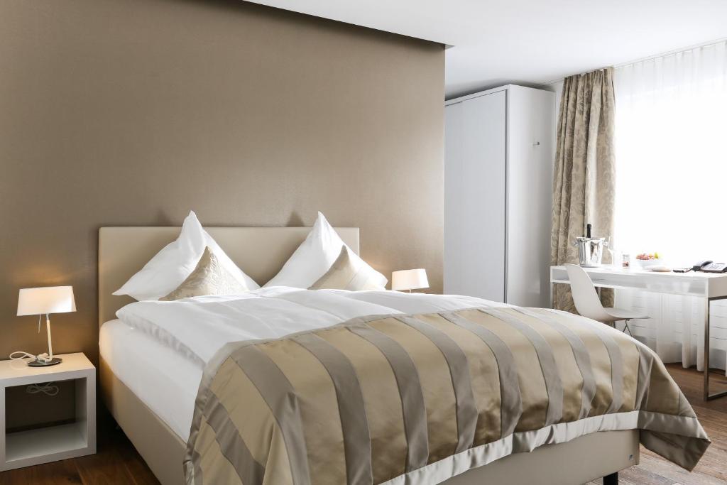 Uzwil乌兹维尔酒店的一间卧室配有一张大床和一张书桌
