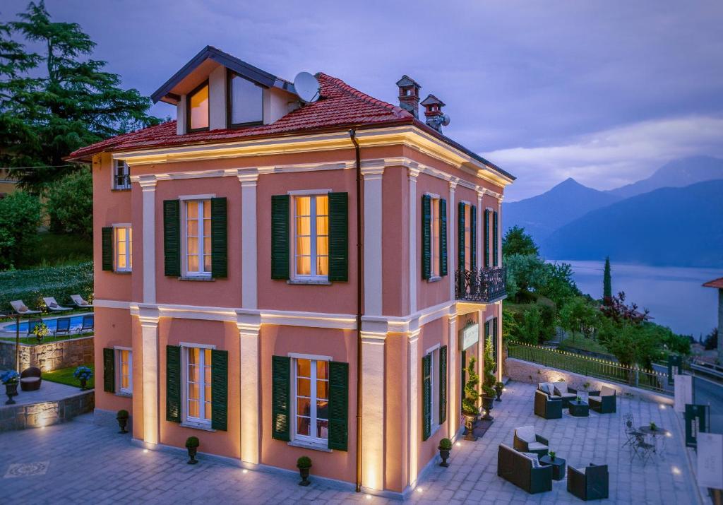 梅纳焦The Lake Como Villa的一座带灯的大型粉红色房子