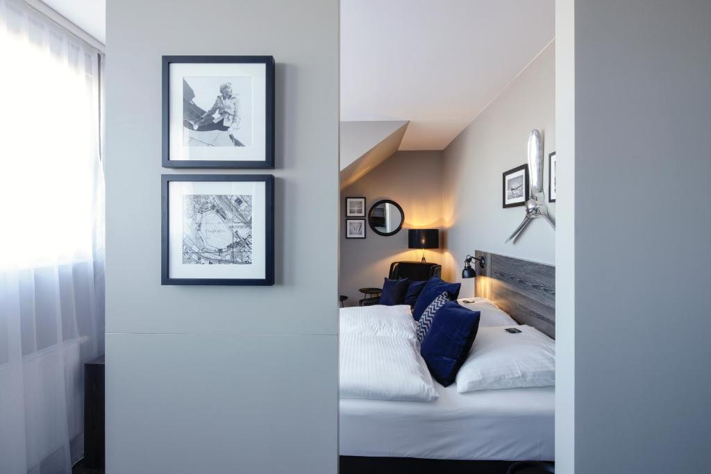 柏林柏林安德尔斯霍夫机场酒店的卧室配有一张床,墙上挂有框图