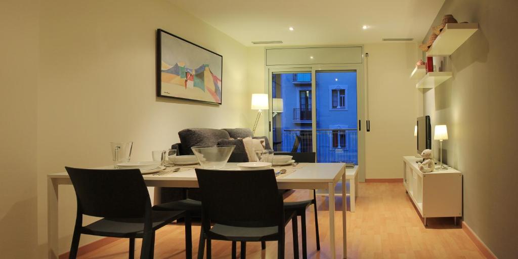 巴塞罗那阿尔格拉工业酒店式公寓的客厅设有餐桌和椅子