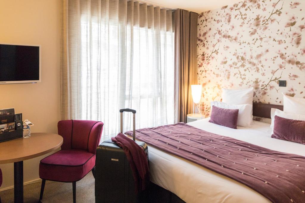 圣马洛Hôtel L'Adresse的酒店客房设有床、桌子和窗户。