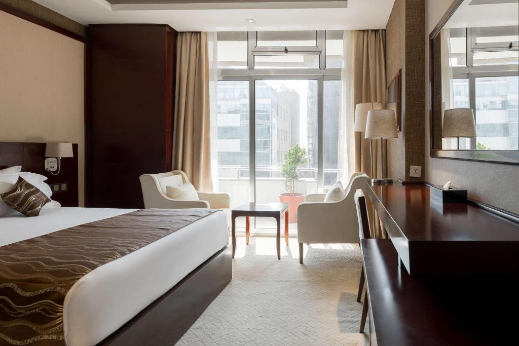 亚的斯亚贝巴Best Western Plus Pearl Addis的酒店客房设有一张床和一个大窗户
