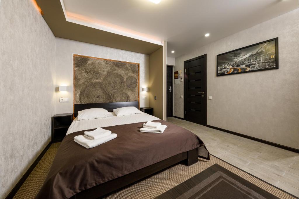 基辅尼维克酒店的一间卧室配有一张大床和毛巾
