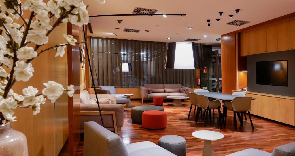 托尔托萨贝伦格尔四世酒店的一间设有桌椅和电视的等候室