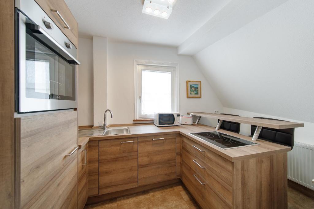 格平根Appartamenti Quattro Ducati的一个带木制橱柜和水槽的厨房