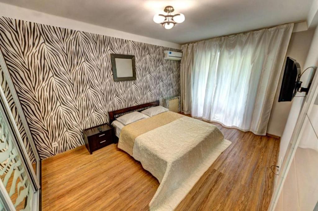 基辅Excellent apartment Druzhby Narodov boulevard 3a. Lybedskaya metro station的一间卧室配有一张床和图案墙壁