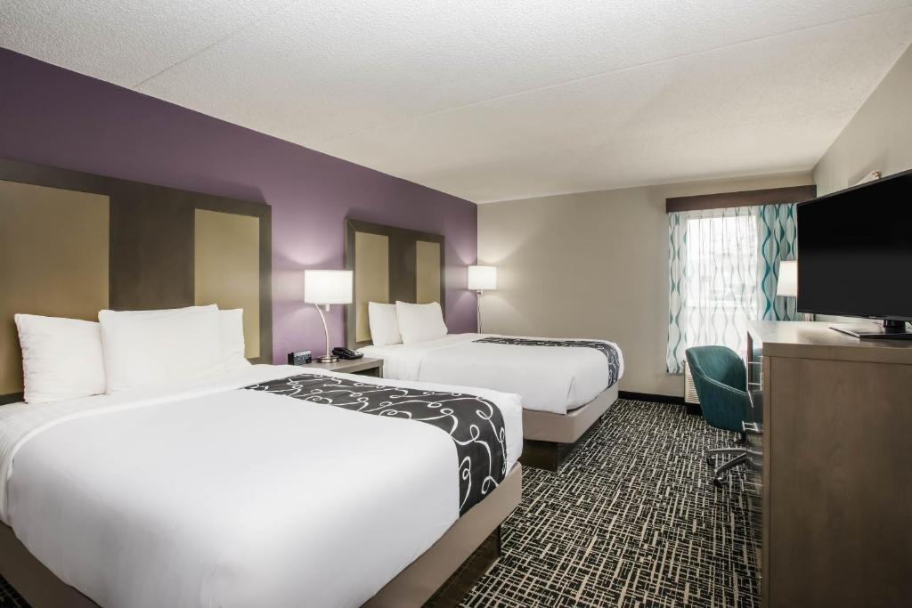 达文波特La Quinta Inn by Wyndham Davenport & Conference Center的酒店客房设有两张床和一台平面电视。