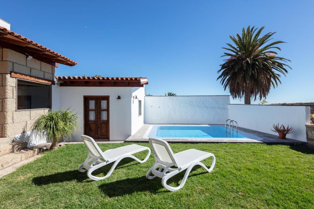 Arico el NuevoEl Sitio de la Casa的一个带2把躺椅和游泳池的庭院