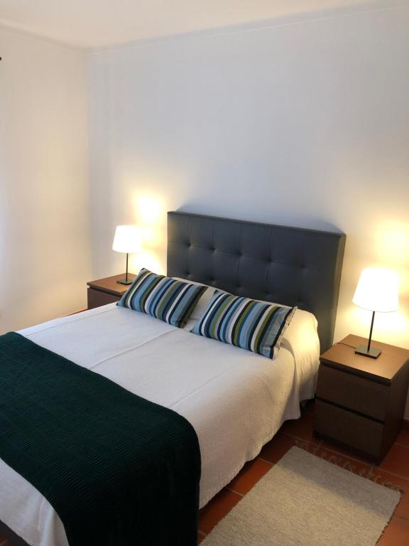 卡尔达斯达·赖尼亚Apartamento - Casas dos Infantes的一间卧室配有一张大床和两盏灯
