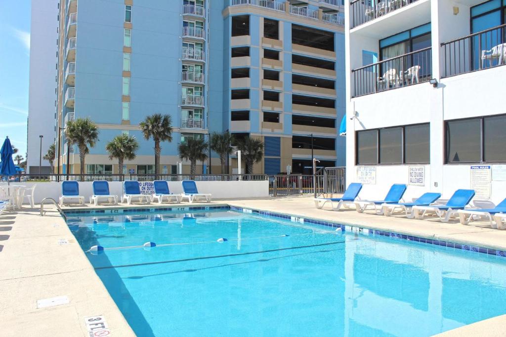 默特尔比奇Holiday Sands South Resort by Palmetto Vacations的一座带躺椅的游泳池和一座建筑