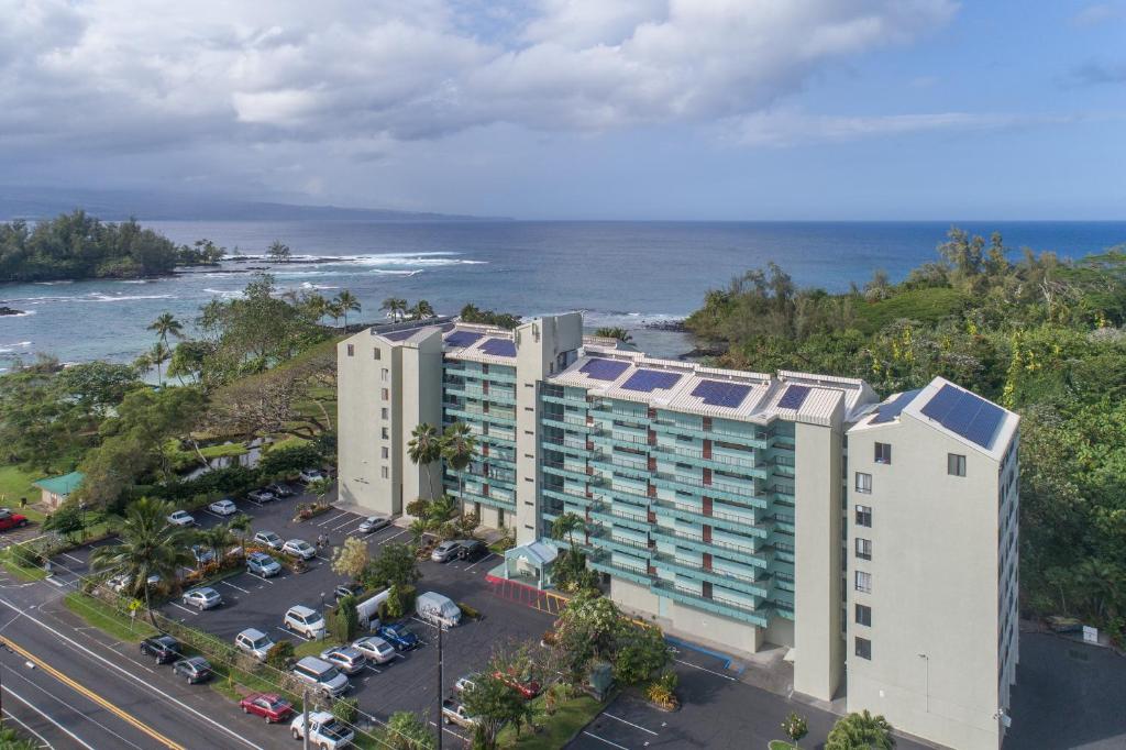 希洛Maluhia Kahakai condo的享有酒店和海洋的空中景致