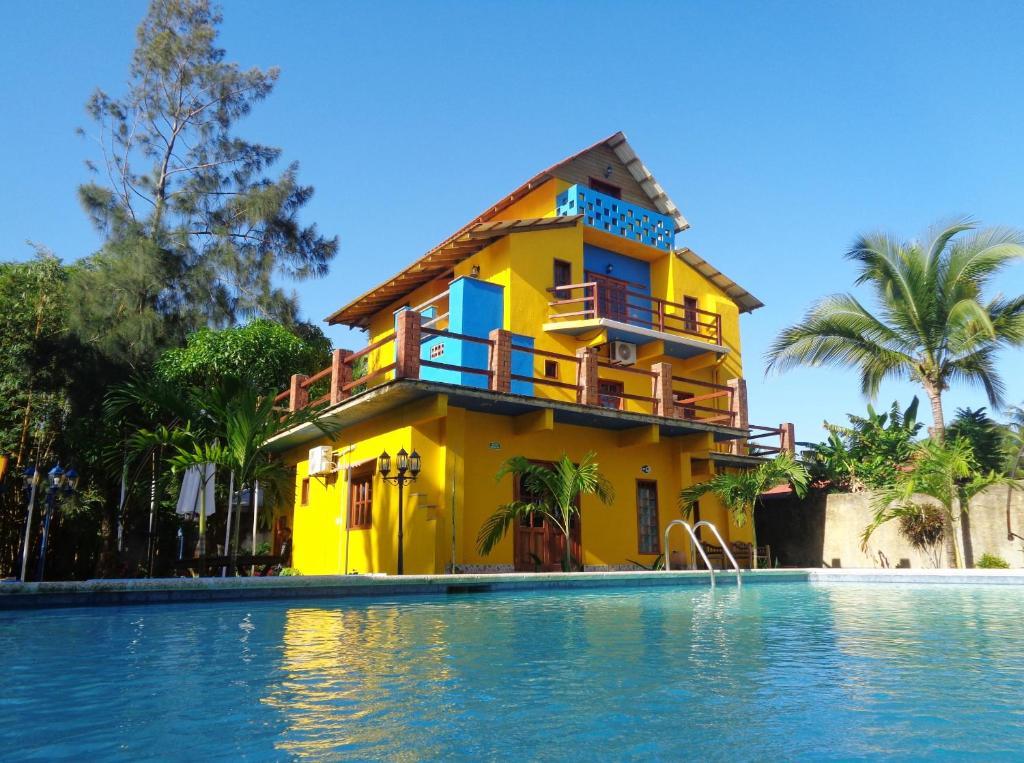 利文斯顿Livingston Resort Hotel的游泳池旁的黄色房子