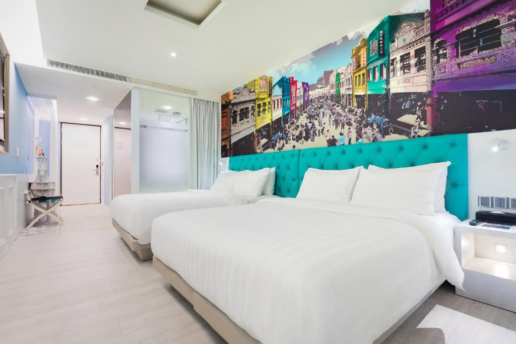 台南富驿时尚酒店的酒店客房设有两张床,墙上挂有绘画作品