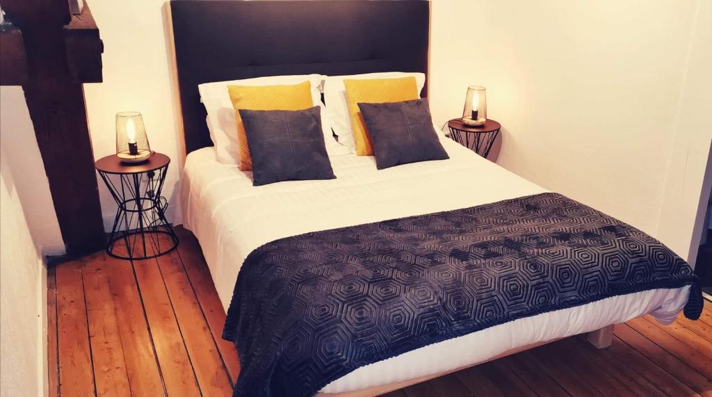 波旁朗西Logis Hotel La Tourelle du Beffroi的一间卧室配有一张带2个床头柜的大床
