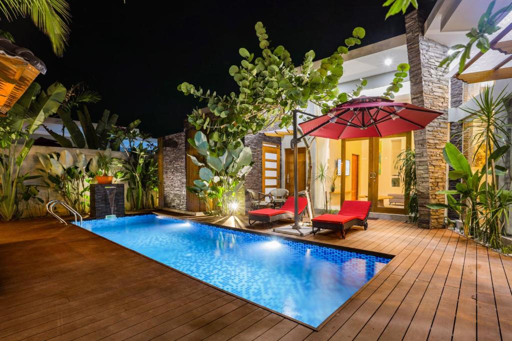 珍南海滩Maneh Villa Langkawi - Private Pool的后院的游泳池,带红伞