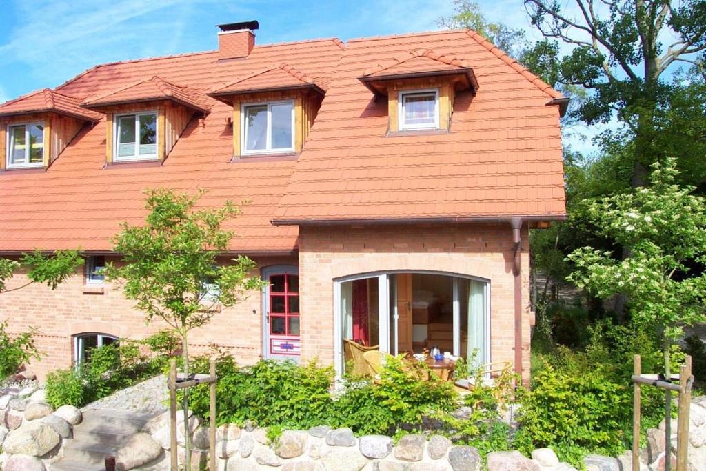 欧巴德伍斯图Dünenhof DÜNENHOF Whg. D-08的一座带橙色屋顶的房屋