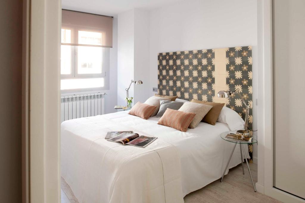 马德里艾瑞克沃科精品公寓 - 阿托查套房的卧室配有一张大白色床和窗户