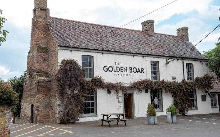 纽马基特The Golden Boar的带有读过哥布林酒吧的标志的建筑