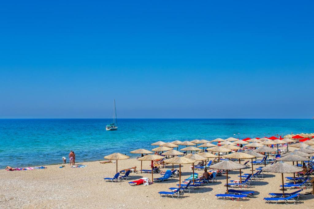 利迈纳里亚Apartments Ralitsa的海滩上有许多椅子和遮阳伞,还有大海