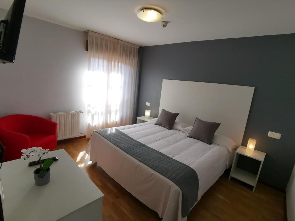 坎加斯-德奥尼斯Hotel El Trasgu的一间卧室配有一张大床和一张红色椅子