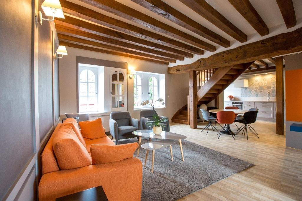 谢韦尔尼Les Suites du Château de Cheverny的客厅配有橙色沙发和桌子