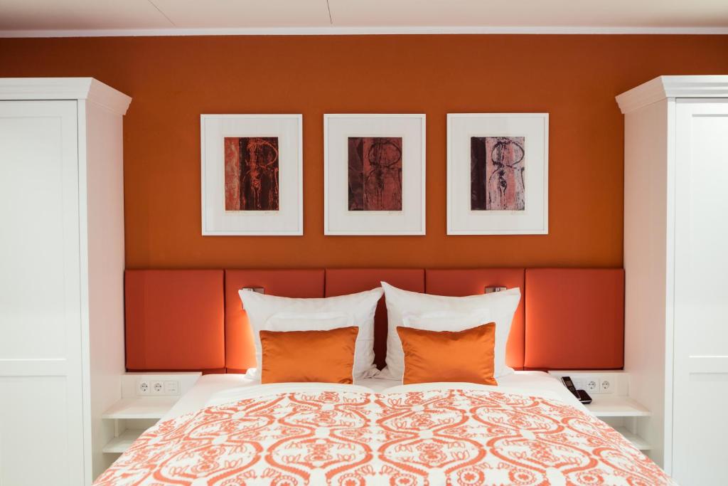 帕绍Passau - Suites的一间卧室拥有橙色的墙壁,床上配有橙色枕头