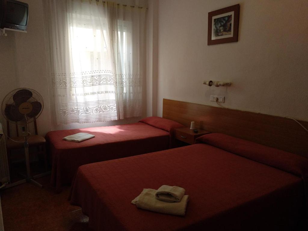 萨拉戈萨PENSION MIRAFLORES的酒店客房设有两张床和窗户。