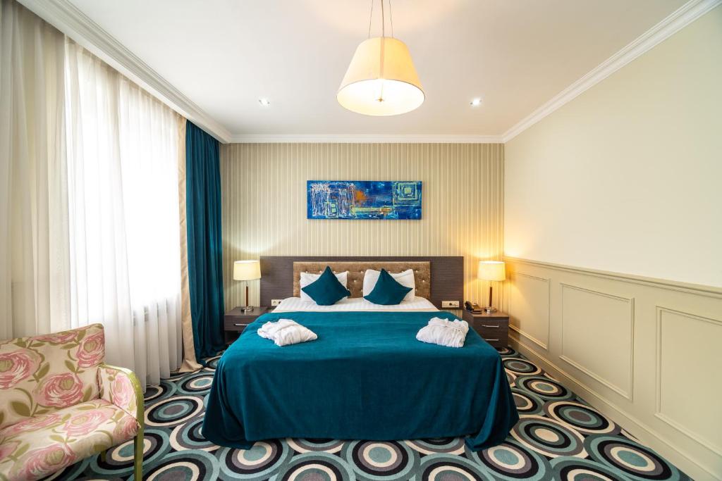 阿拉木图Mildom Hotel的一间卧室配有蓝色的床和椅子