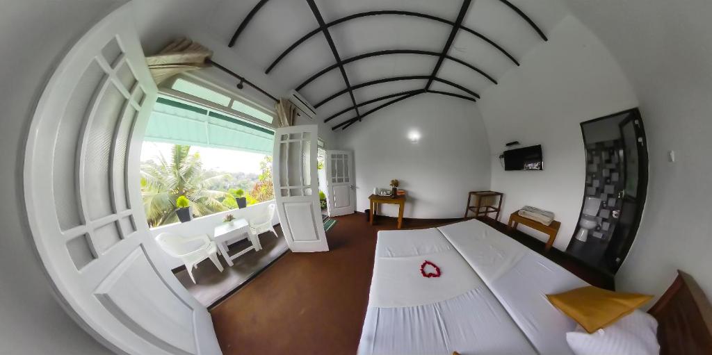 康提Kandy Mountain Cottage的一间设有大窗户的白色大客房