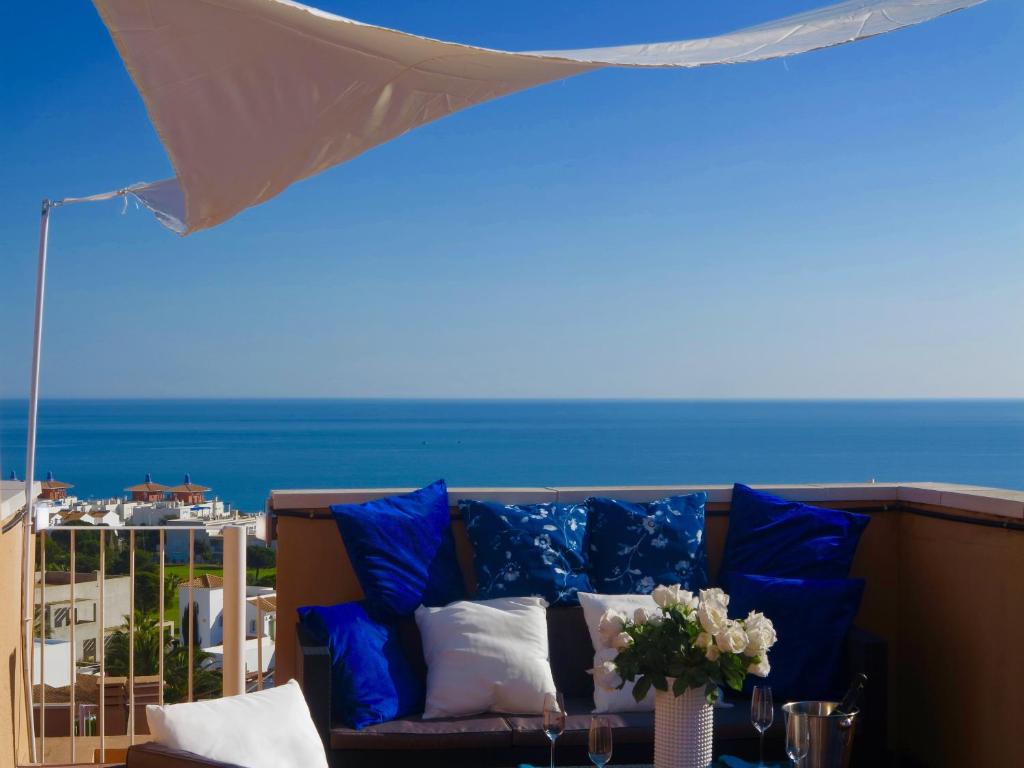 莫哈卡尔Penthouse Aloha4you的海景阳台上的沙发配有蓝色枕头