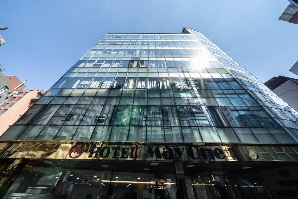 首尔MAYONE HOTEL Myeongdong的一座高大的玻璃建筑,上面写着“我的酒店”