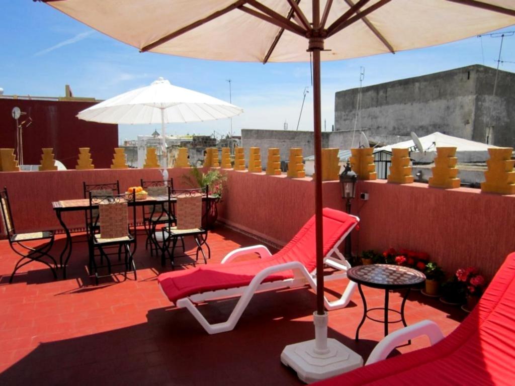 拉巴特达尔亚尼斯旅馆的庭院配有桌椅和遮阳伞。