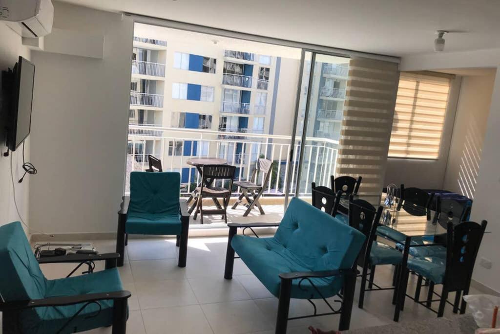 里考尔特Apartamento cómodo con todo lo que necesitas con Aire Acondicionado !!的一间带蓝色椅子的客厅和一个阳台