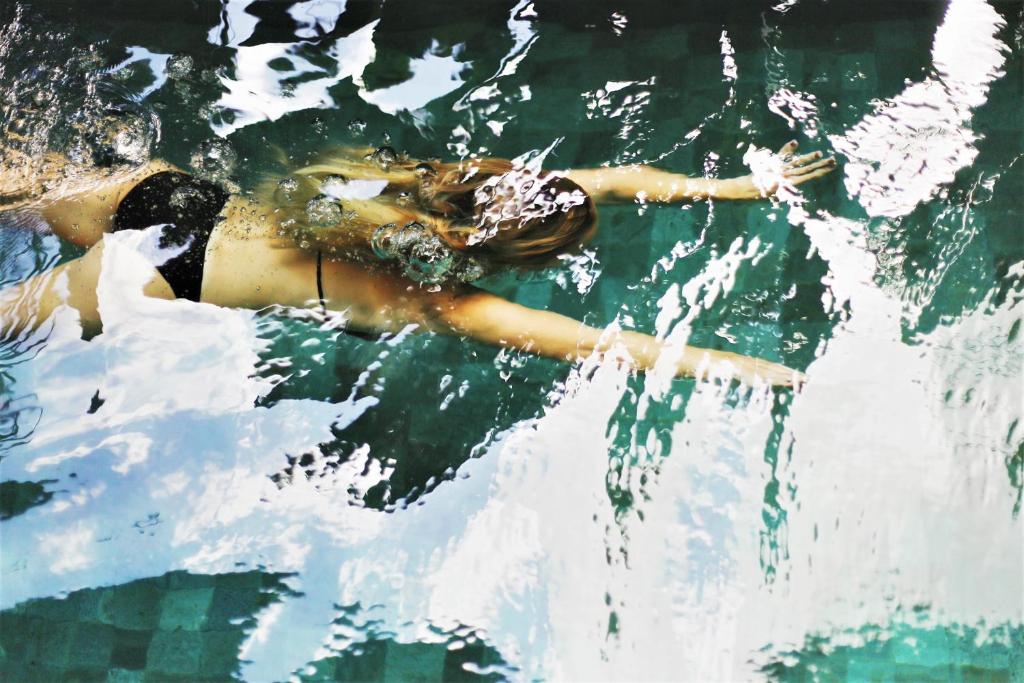 罗维尼卡萨爱丽丝酒店的漂浮在水中的一个女人