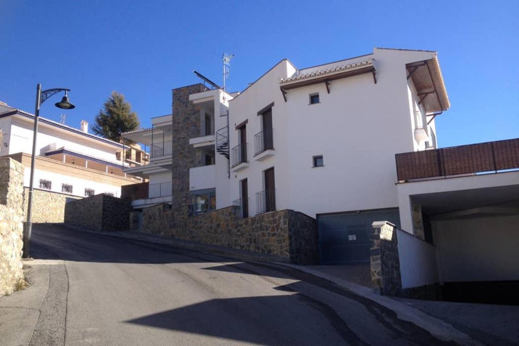 圭哈尔谢拉Sierra Nevada Luxury Getaway的白色建筑前的一条空的街道