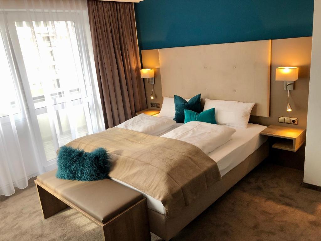 巴特法兴格Appartementhotel Cura Bad Füssing的一间卧室设有一张蓝色墙壁的大床