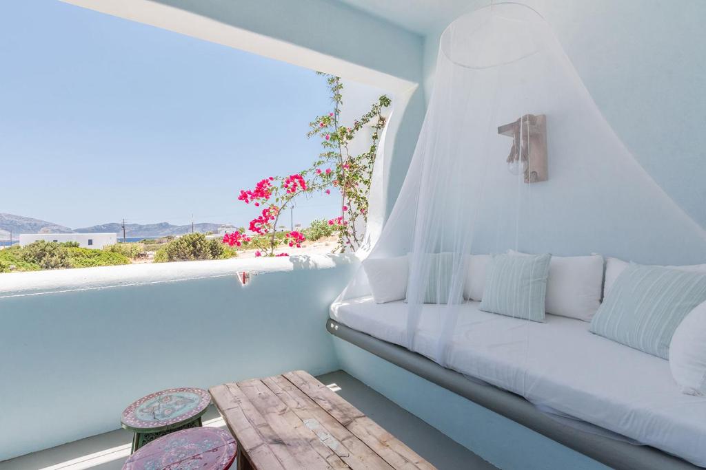 考弗尼西亚Pangaia Seaside Ηotel Adults Only的白色的客房设有长凳和窗户。