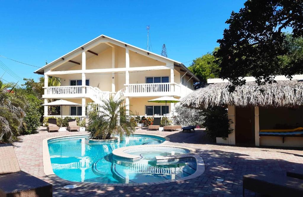 威廉斯塔德瓦亚卡迷你度假公寓的一座带游泳池的度假村,位于一座建筑前