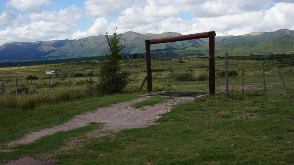 拉库布蕾Los Chañaritos的一条土路,在有栅栏和山 ⁇ 的田野里