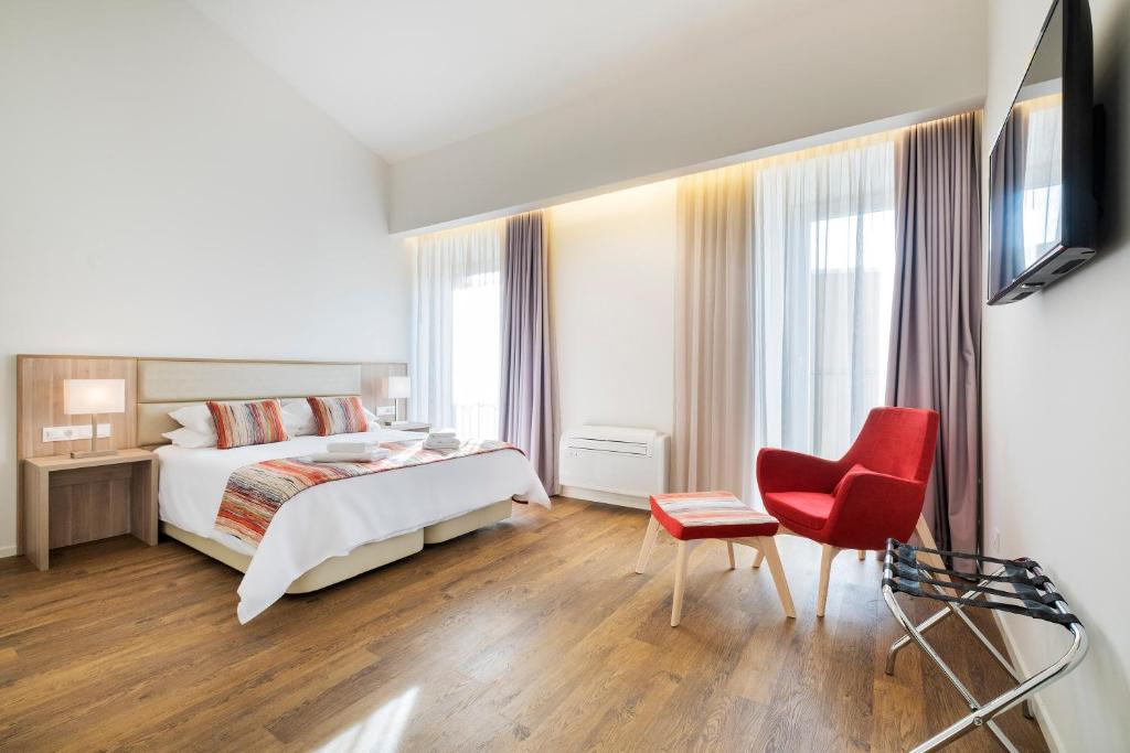 蓬塔德尔加达Casas Amarelas Azores的酒店客房,配有一张床和一张红色椅子