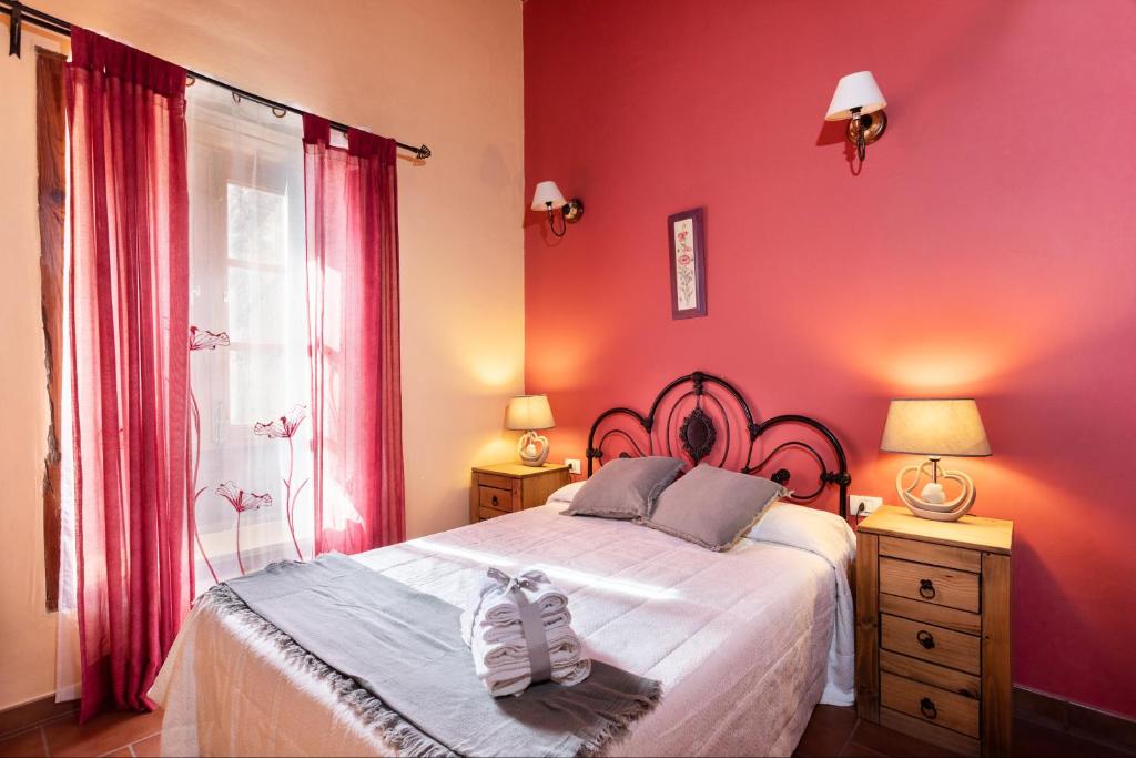 El Pinar del HierroCasa Rural La Pestilla 1的卧室设有粉红色的墙壁和一张带鞋的床