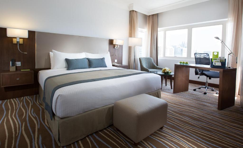 阿布扎比Copthorne Downtown by Millennium的酒店客房设有一张大床和一张书桌。