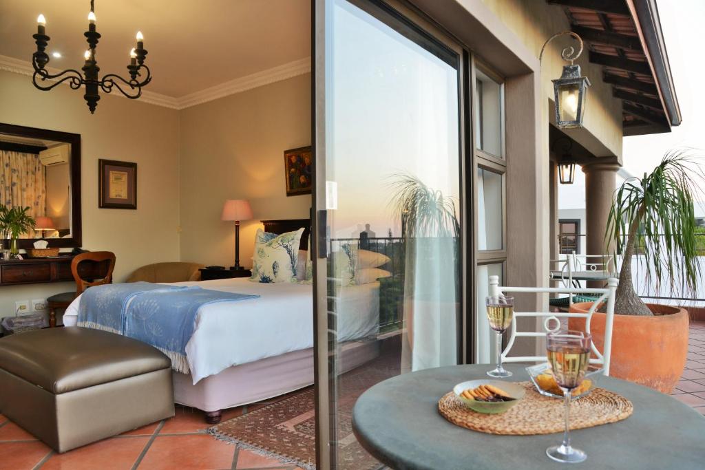 巴利托巴利托葡萄园宾馆的一间卧室配有一张床和一张带酒杯的桌子