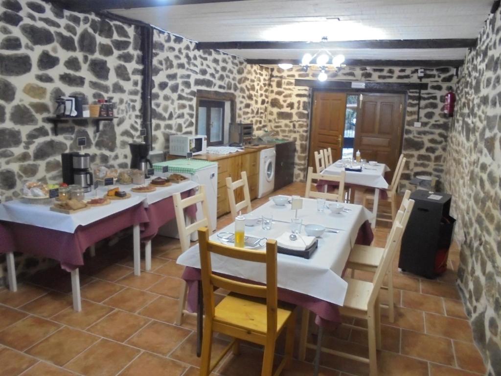 ArceAlbergue Areitz Soroa的一间设有两张桌子和椅子的用餐室,拥有石墙