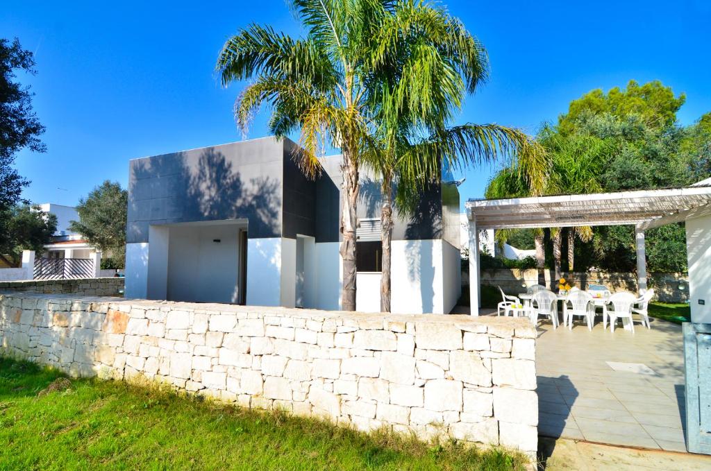 托雷科里梅纳Villa Giusi的一座石墙和棕榈树的房子