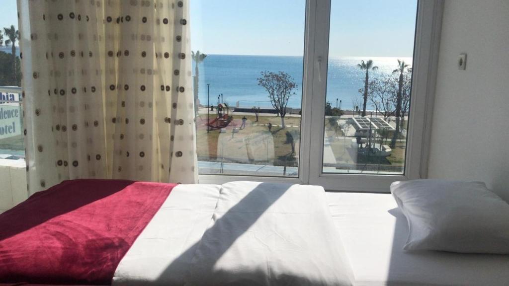 安塔利亚奥尔比亚公寓酒店的一间卧室设有一张床和一个大窗户