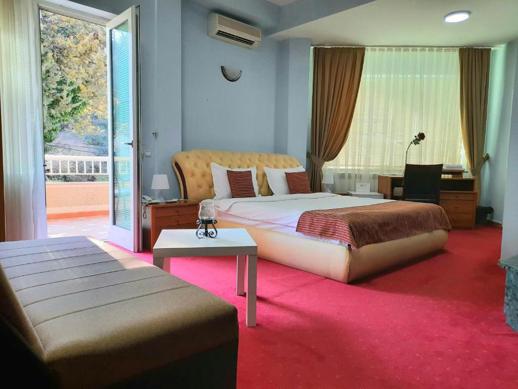 斯科普里Hotel Aristocrat & Fish Restaurant的一间卧室配有一张床、一张书桌和一个窗户。