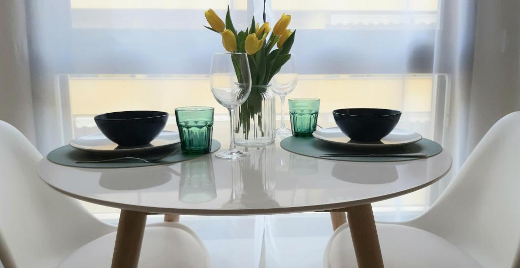 莫莱拉Marjeleta Apartamento的白色桌子,花瓶和眼镜
