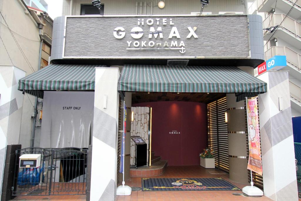 横滨Gomax (Adult Only)的建筑物上带绿色遮篷的商店前