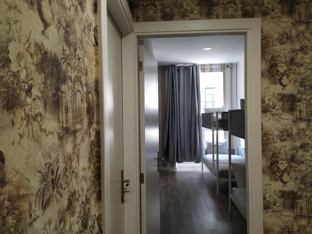 波尔图Majestic Hostel Porto的走廊上设有通往卧室的门